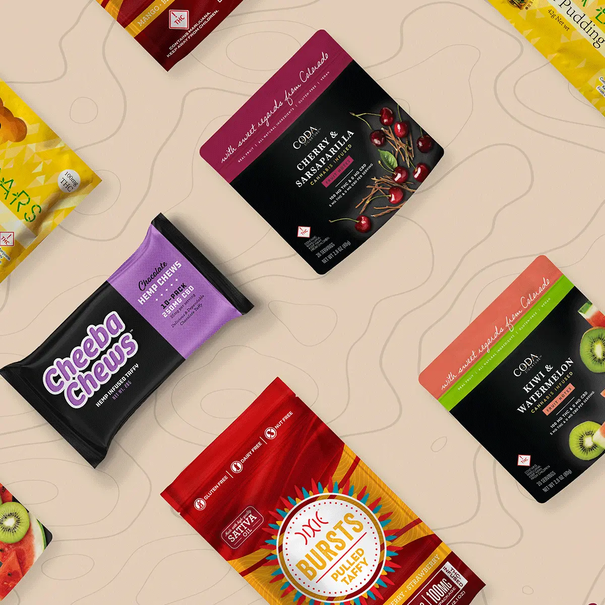 Assorted cannabis edible products and packaging including gummies, chocolates, and various branded packages displayed on wooden background