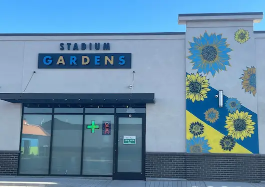 Gardens Dispensary Stadium location storefront with blue sunflower decorations